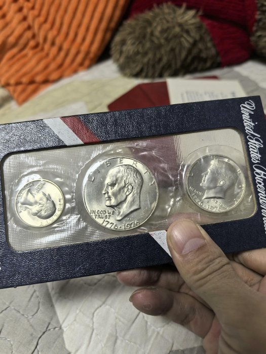 嚴選1976年美國慶祝獨立200週年紀念銀幣套裝，包含一枚美元、半美元及25美分硬幣，完整保存在原始防拆封套中。